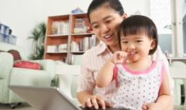 [Illustration of woman holding child looking at computer] Click the button below the non-discimination notice
